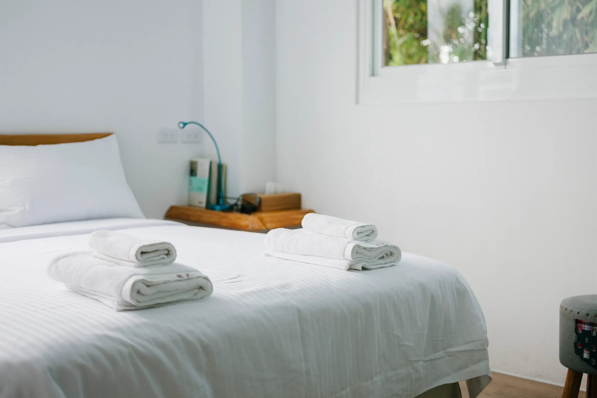 Freshly made bed with folded white towels
